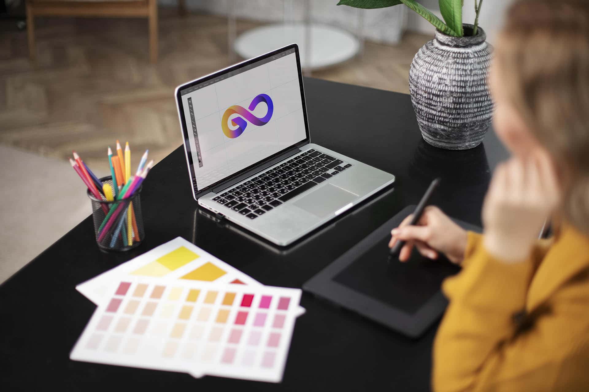female-logo-designer-working-her-tablet-connected-laptop-min